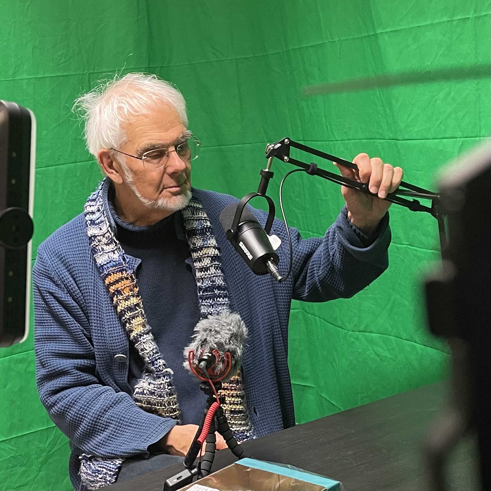 Bakom kulisserna: röstinspelning framför greenscreen med mikrofon i studiomiljö.